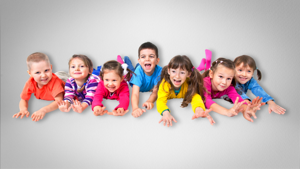 Lachende Kindergartenkinder liegen im Kindertanzkurs auf dem Boden