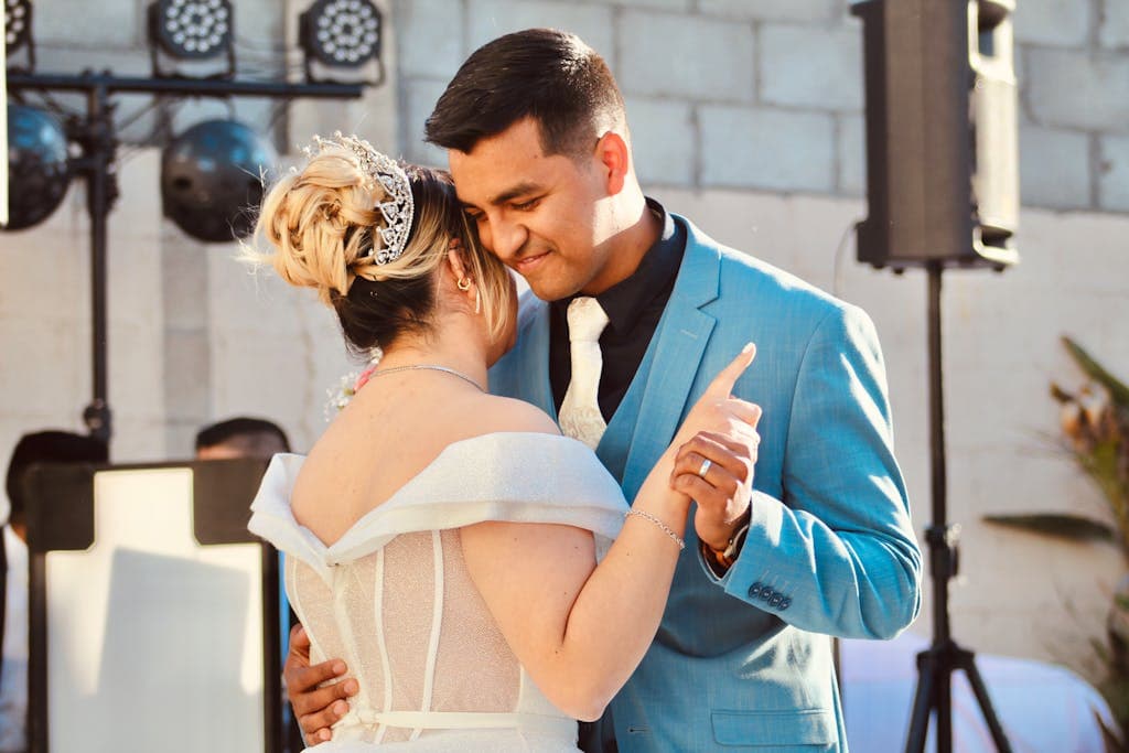 Bride and groom sharing a heartfelt dance outdoor during their wedding day.